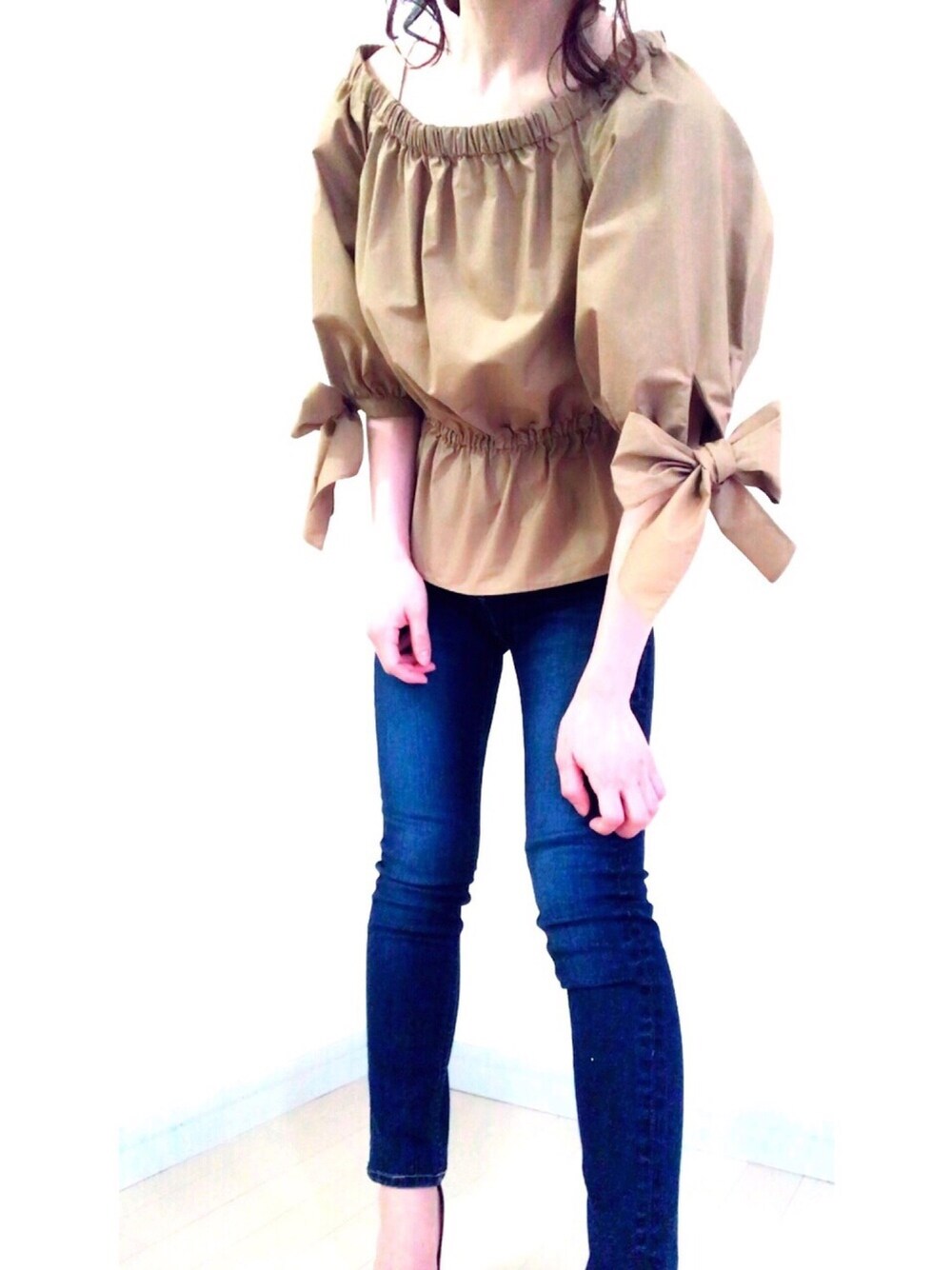 ブルー系のデニムパンツ、ベージュ系のシャツ/ブラウスを着用したレディースの春コーディネートの1枚目の写真