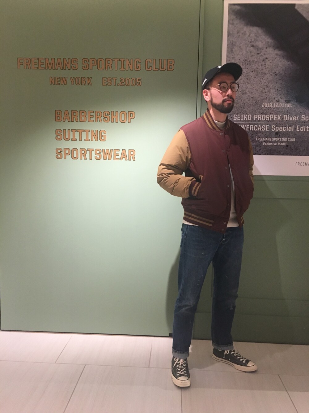 レッド系のダウンジャケット/コート、ブルー系のデニムパンツ、グリーン系のスニーカーを着用したメンズの冬コーディネートの1枚目の写真