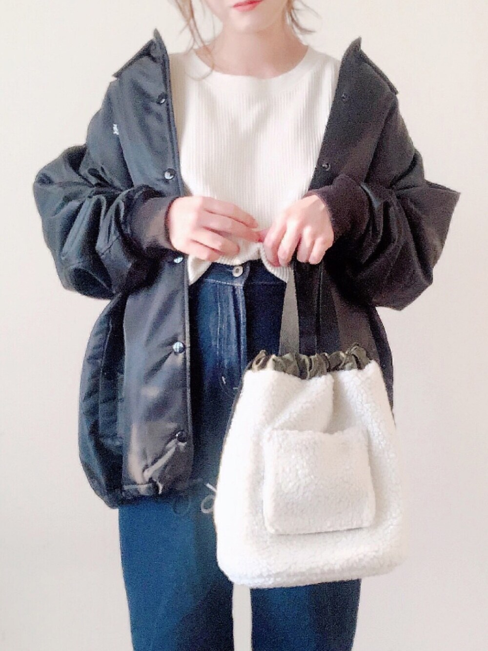ブルー系のデニムパンツ、グリーン系のトートバッグ、ホワイト系のTシャツ/カットソーを着用したレディースの秋コーディネートの1枚目の写真