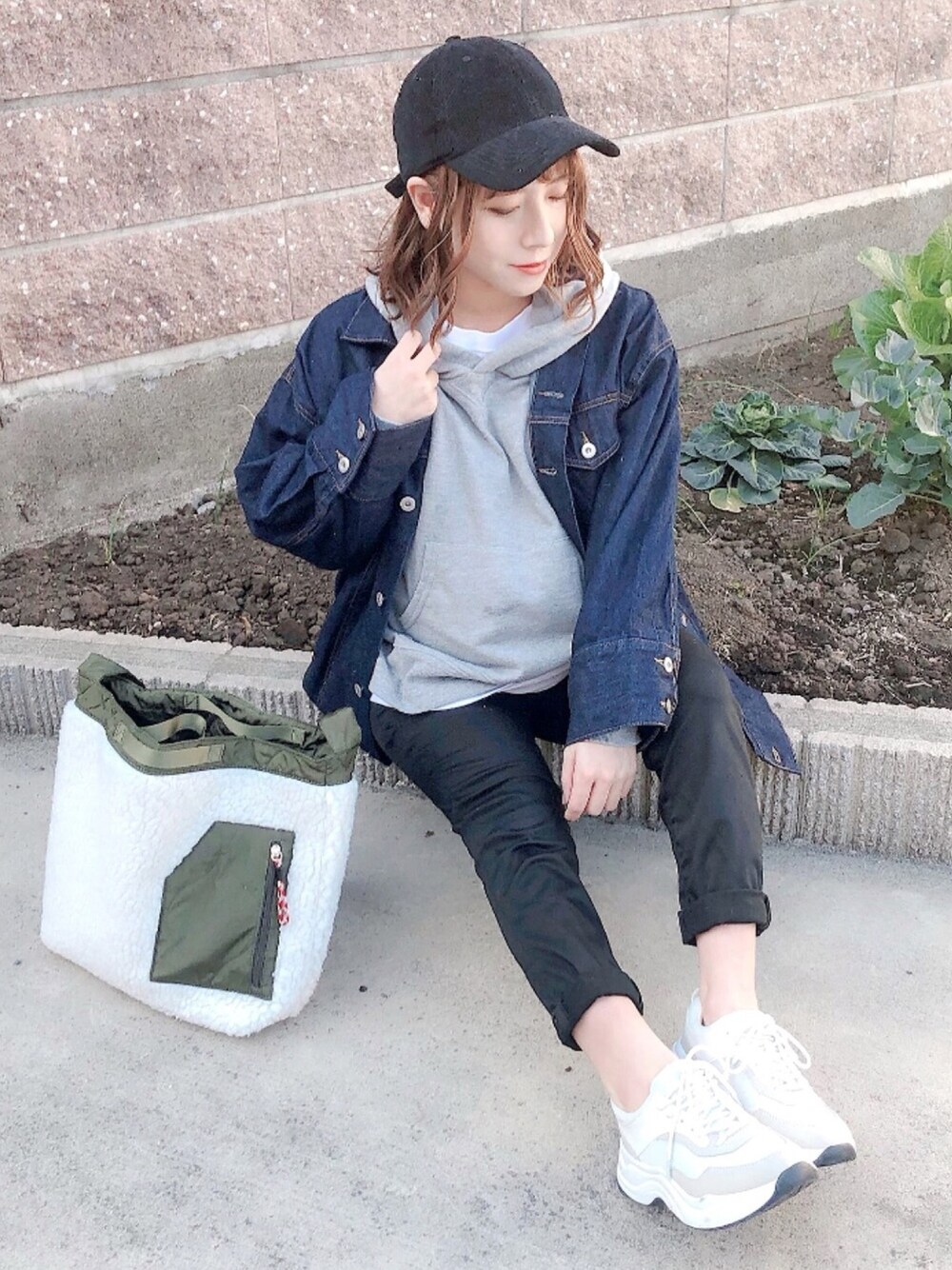 グレー系のパーカー、ブルー系のデニムジャケット、ホワイト系のTシャツ/カットソーを着用したレディースの冬コーディネートの1枚目の写真