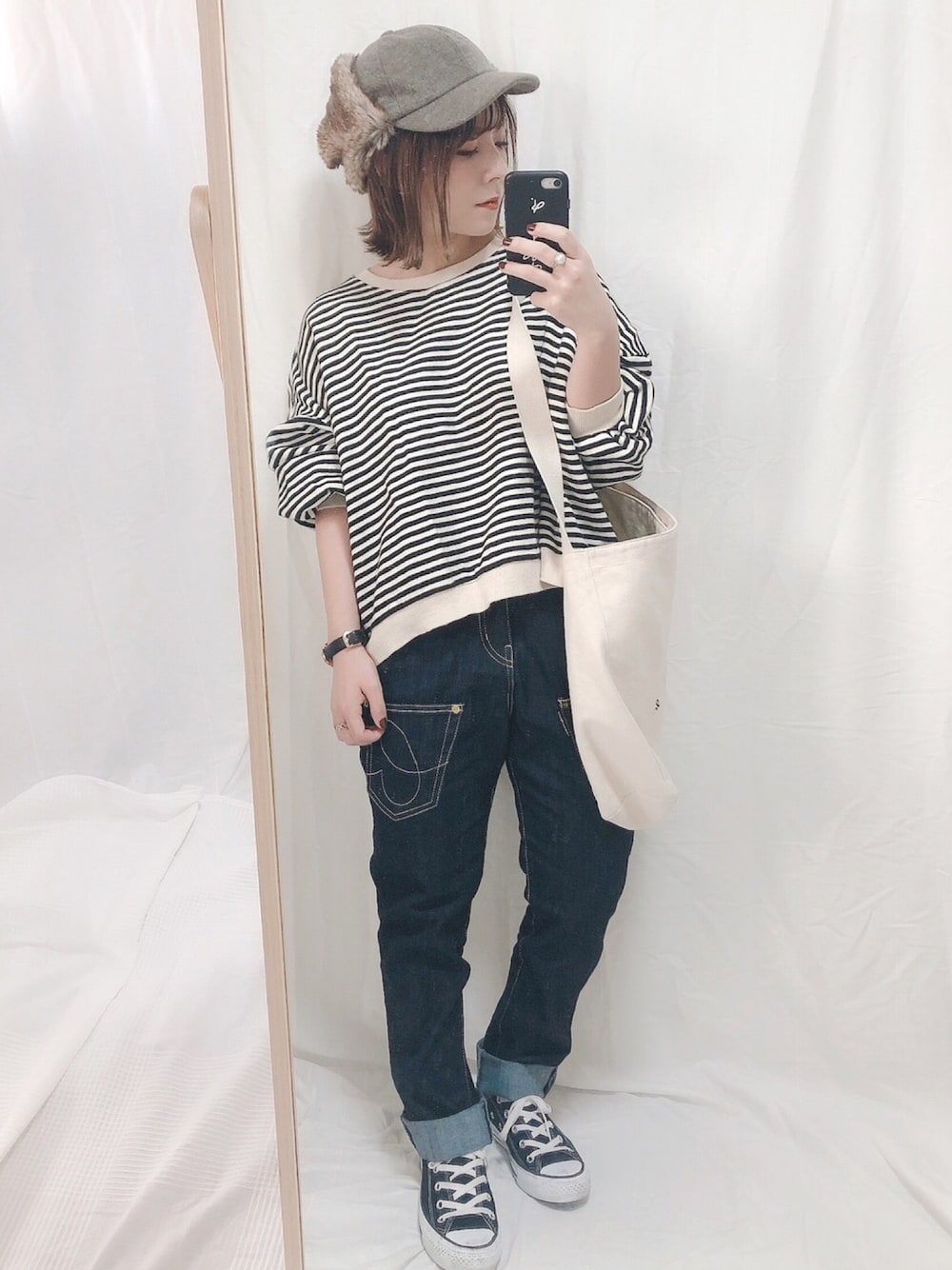 ブルー系のデニムパンツ、ブラック系のスニーカー、ブラウン系のキャップを着用したレディースの夏コーディネートの1枚目の写真