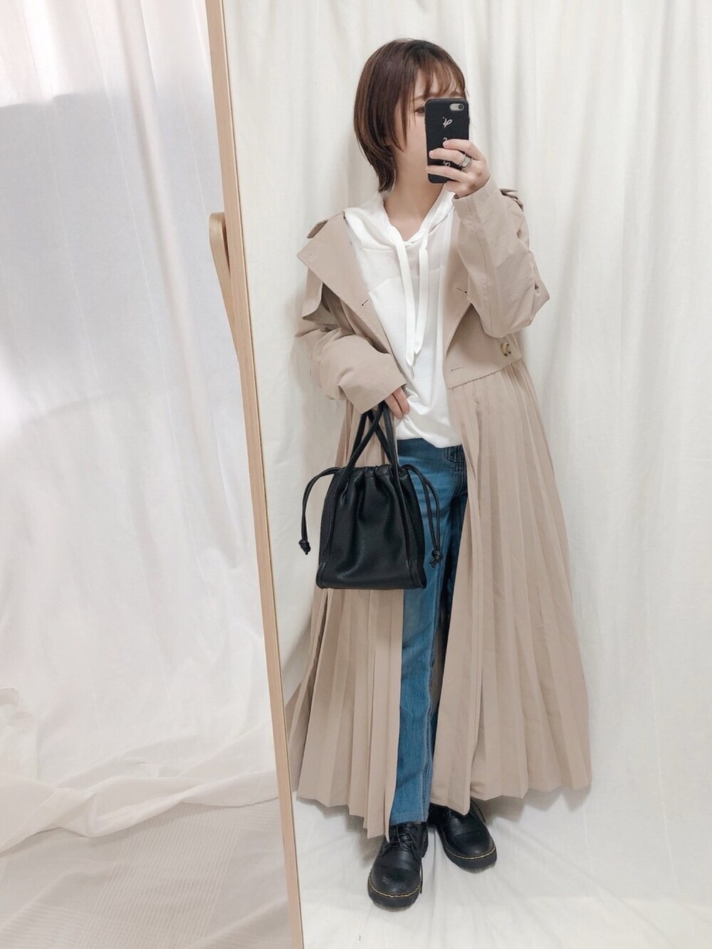 ホワイト系のTシャツ/カットソー、ベージュ系のトレンチコート、ブラック系のショルダーバッグを着用したレディースの冬コーディネートの1枚目の写真