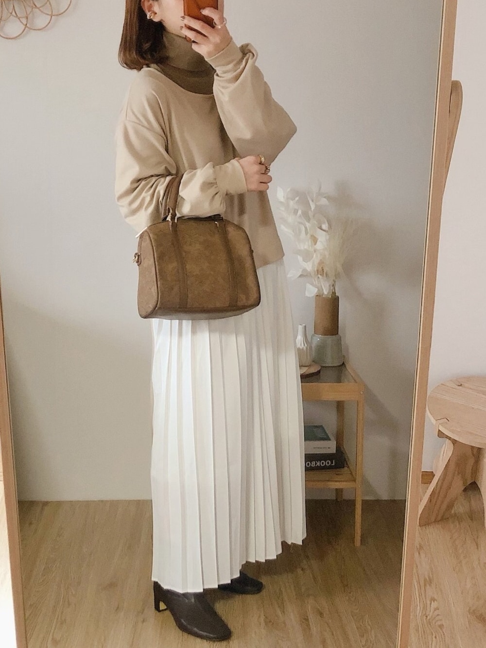 ベージュ系のワンピース、ベージュ系のTシャツ/カットソー、ブラウン系のショルダーバッグを着用したレディースの冬コーディネートの1枚目の写真