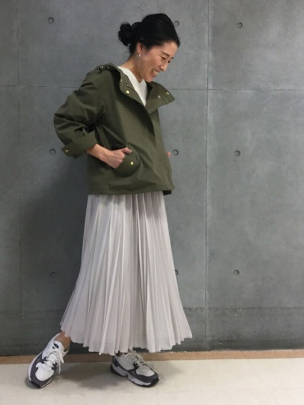 グレー系のニット/セーター、ブルー系のマウンテンパーカー、グレー系のスカートを着用したレディースの冬コーディネートの1枚目の写真