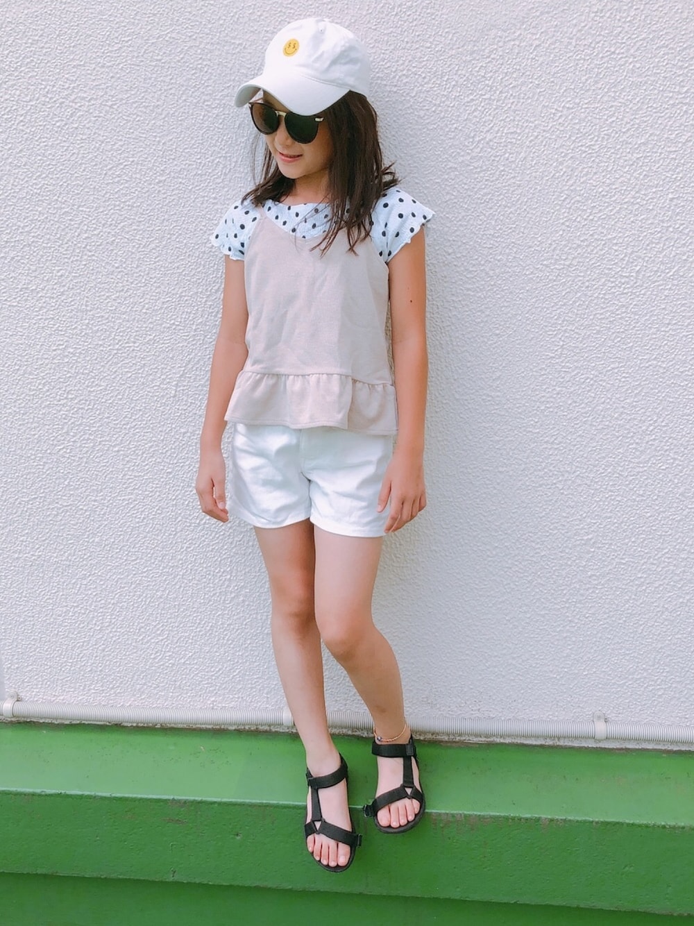 ホワイト系のTシャツ/カットソー、ベージュ系のキャミソール、ホワイト系のデニムパンツを着用したキッズの夏コーディネートの1枚目の写真