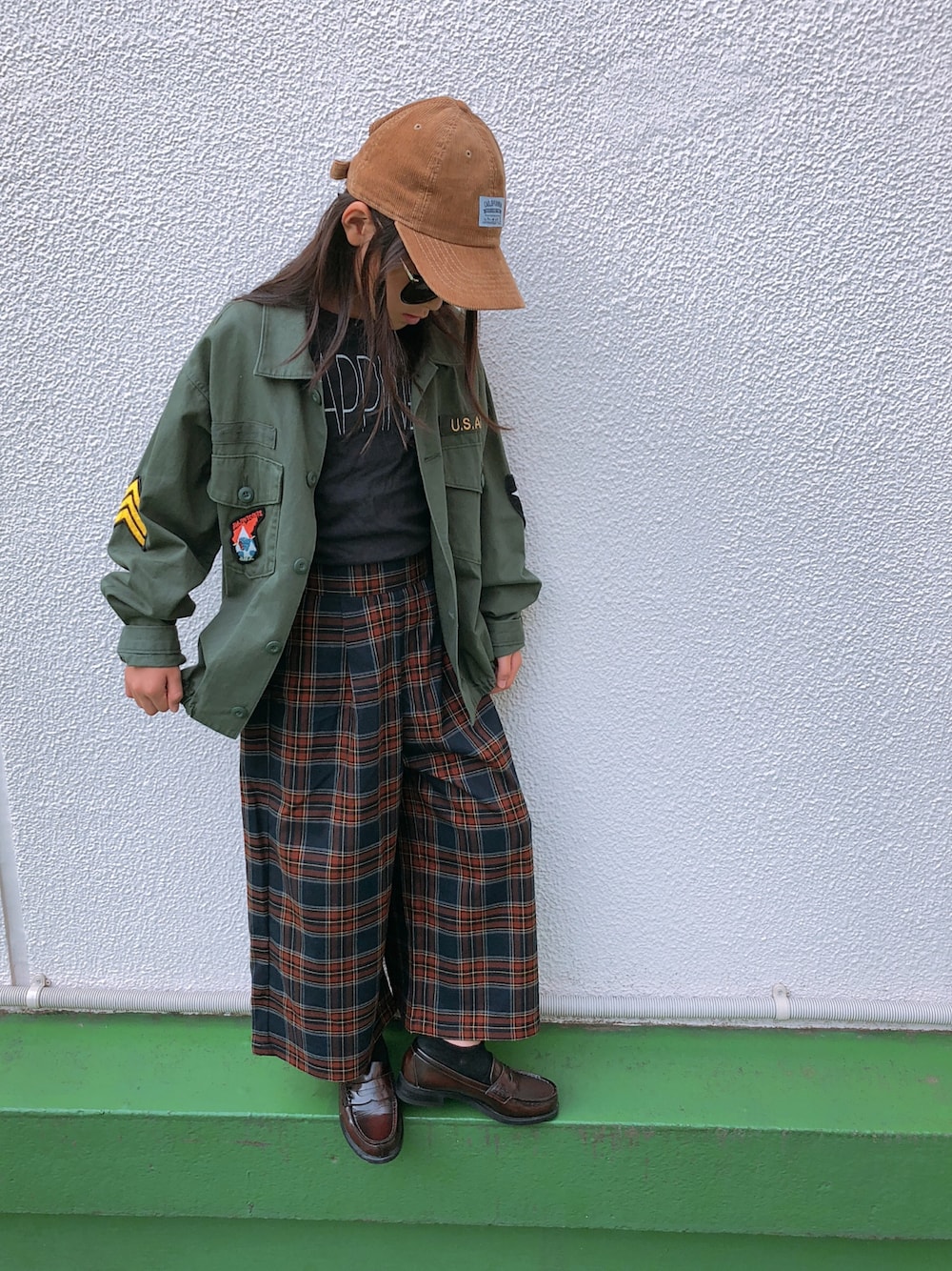 ブラウン系のパンツ、ブラック系のTシャツ/カットソー、ブラウン系のローファーを着用したキッズの秋コーディネートの1枚目の写真