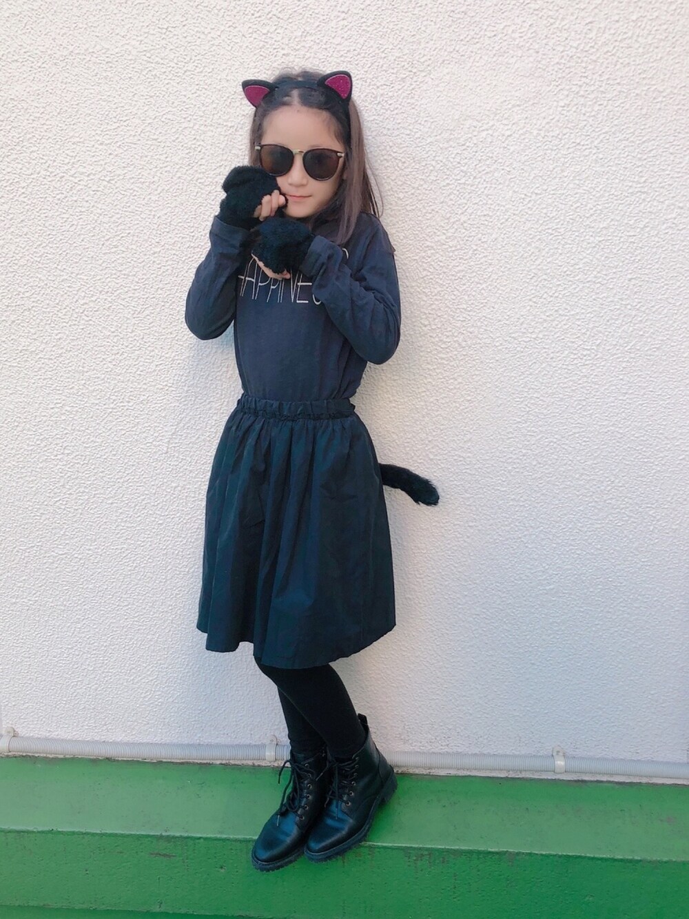 ブラック系のTシャツ/カットソー、ブラック系のスカート、ブラック系のブーツを着用したキッズの秋コーディネートの1枚目の写真