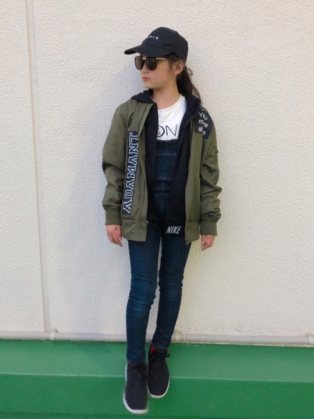 ブラック系のバッグ、ブラック系のパーカー、ブルー系のサロペット/オーバーオールを着用したキッズの春コーディネートの1枚目の写真