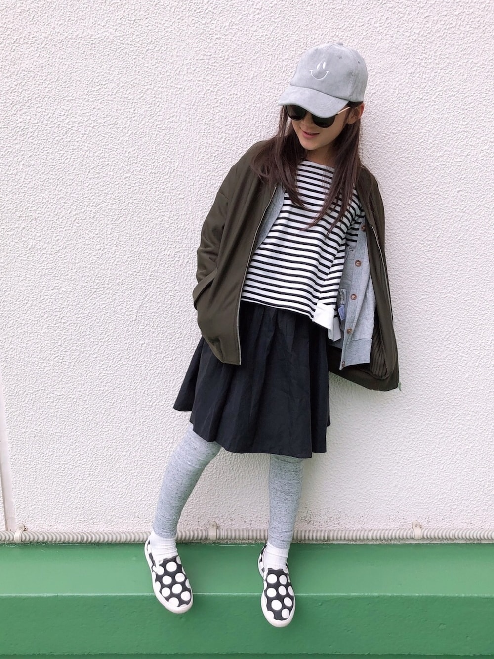 ホワイト系のTシャツ/カットソー、グレー系のカーディガン/ボレロ、ブラック系のスカートを着用したキッズの春コーディネートの1枚目の写真