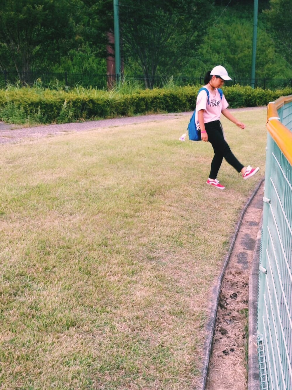 レッド系のスニーカー、ブルー系のバックパック/リュック、グレー系のキャップを着用したレディースの冬コーディネートの1枚目の写真