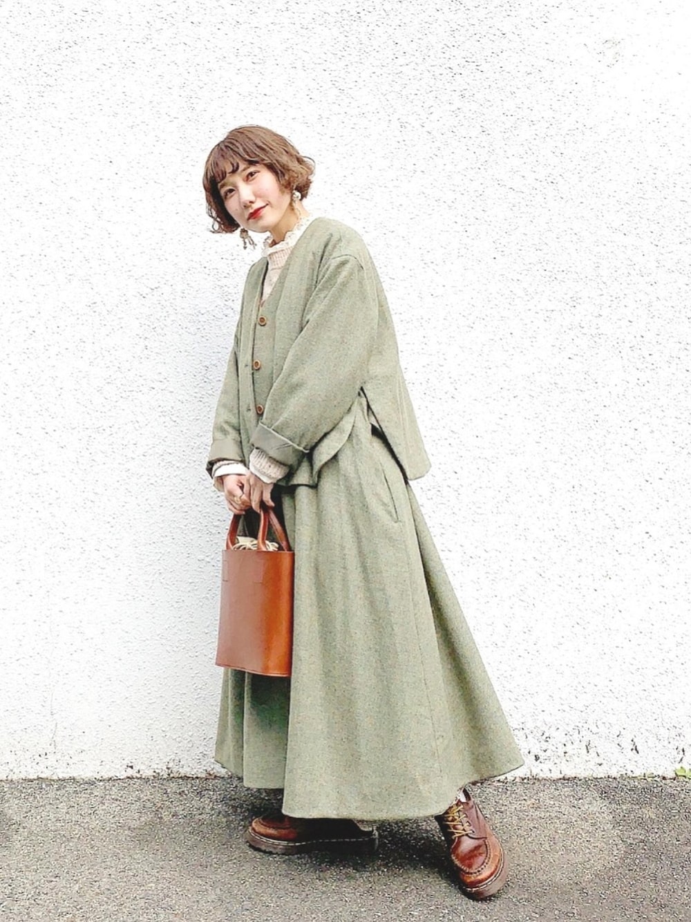 グリーン系のその他アウター、ブラウン系のトートバッグを着用したレディースの冬コーディネートの1枚目の写真