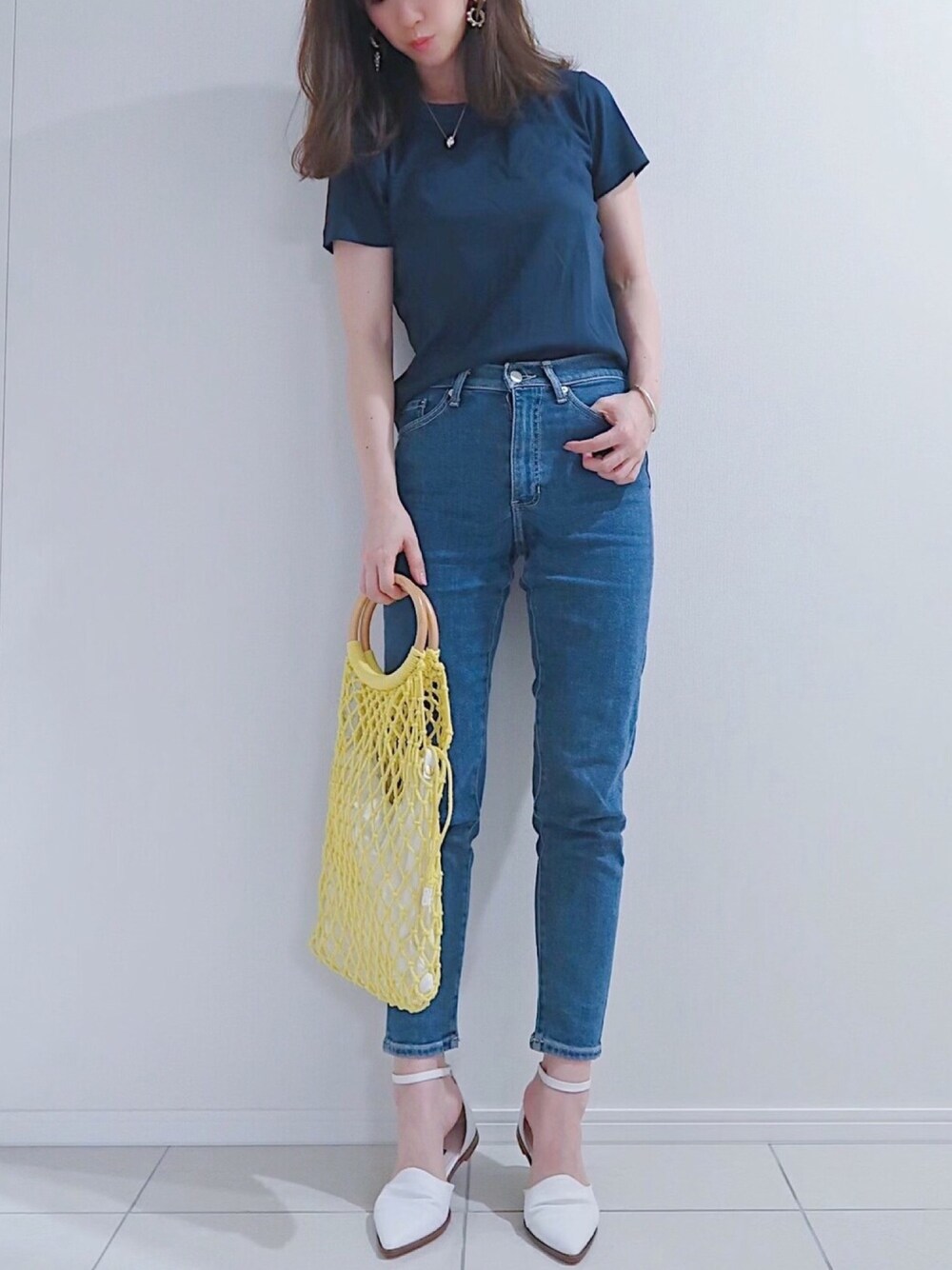 ブルー系のTシャツ/カットソー、ブルー系のデニムパンツ、イエロー系のかごバッグを着用したレディースの夏コーディネートの1枚目の写真