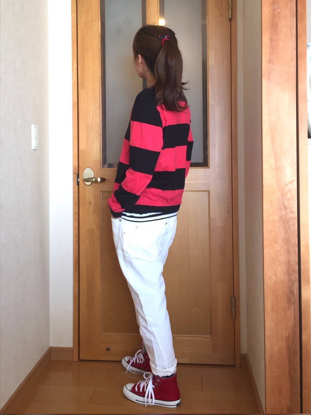 レッド系のスニーカー、ホワイト系のデニムパンツ、ホワイト系のTシャツ/カットソーを着用したレディースの冬コーディネートの1枚目の写真