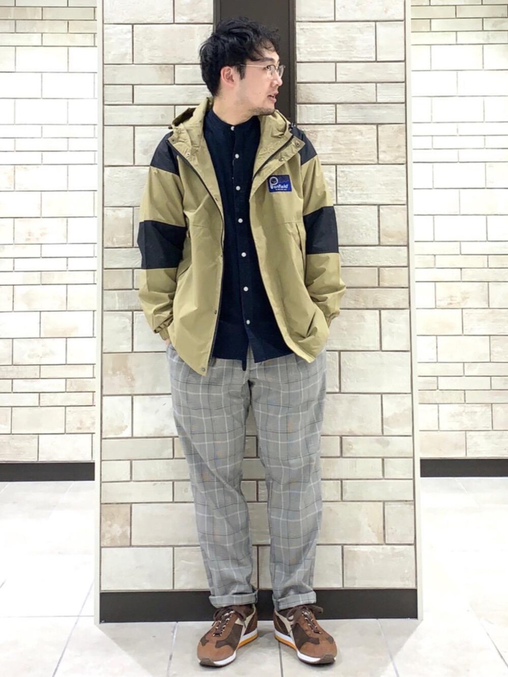 ベージュ系のマウンテンパーカー、グレー系のその他パンツ、ブルー系のシャツ/ブラウスを着用したメンズの春コーディネートの1枚目の写真