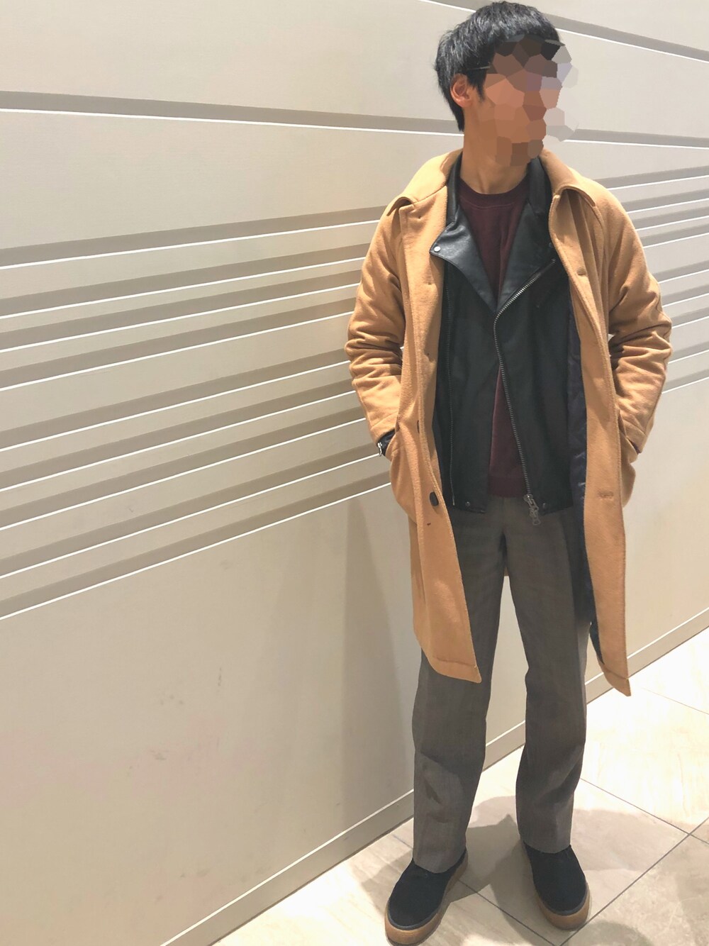 ブラック系のライダースジャケット、イエロー系のステンカラーコート、ブラック系のスニーカーを着用したメンズの冬コーディネートの1枚目の写真
