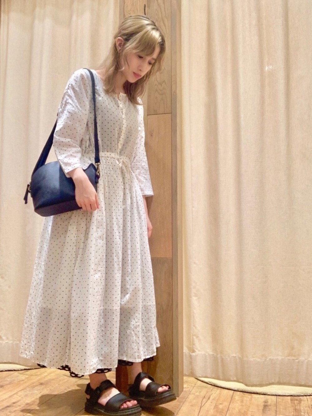 ホワイト系のワンピース、ブラック系のショルダーバッグ、ブラック系のスカートを着用したレディースの夏コーディネートの1枚目の写真