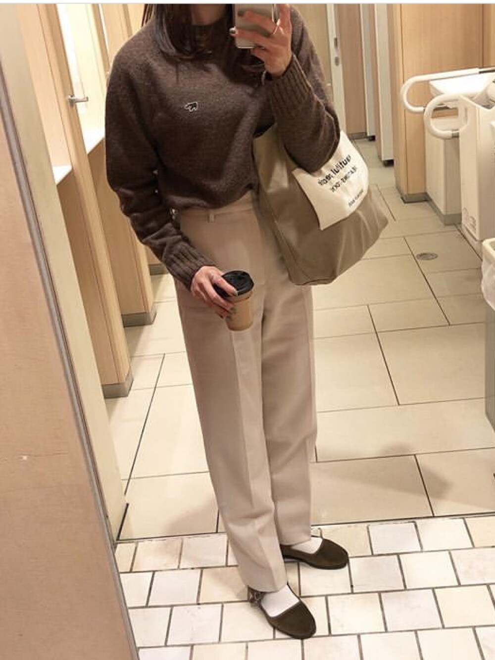 ホワイト系のその他パンツ、ブラウン系のニット/セーター、ブラウン系のトートバッグを着用したレディースの冬コーディネートの1枚目の写真