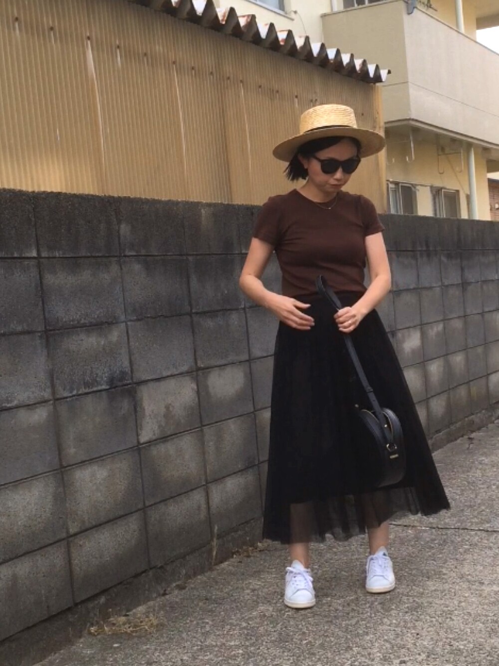 ブラウン系のTシャツ/カットソー、ブラック系のスカート、ブラック系のショルダーバッグを着用したレディースの夏コーディネートの1枚目の写真