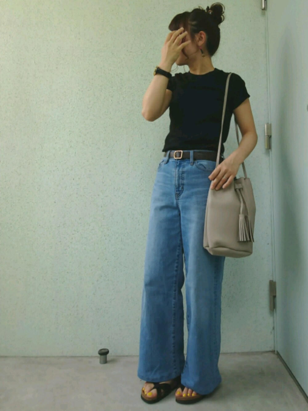 ブラック系のサンダル、グレー系のバッグ、ブルー系のデニムパンツを着用したレディースの夏コーディネートの1枚目の写真