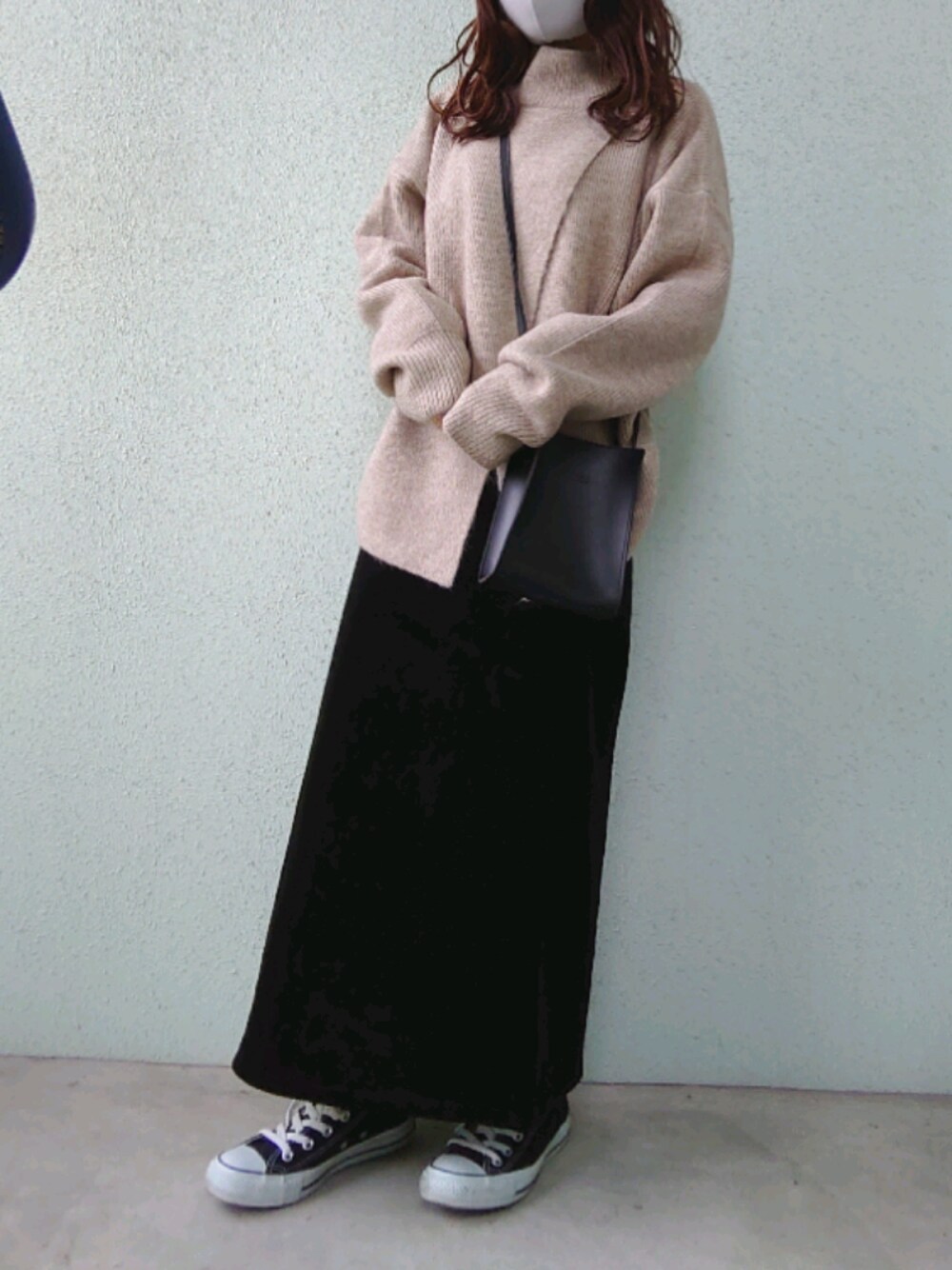 ブラック系のスカート、ベージュ系のニット/セーター、ブラック系のスニーカーを着用したレディースの冬コーディネートの1枚目の写真