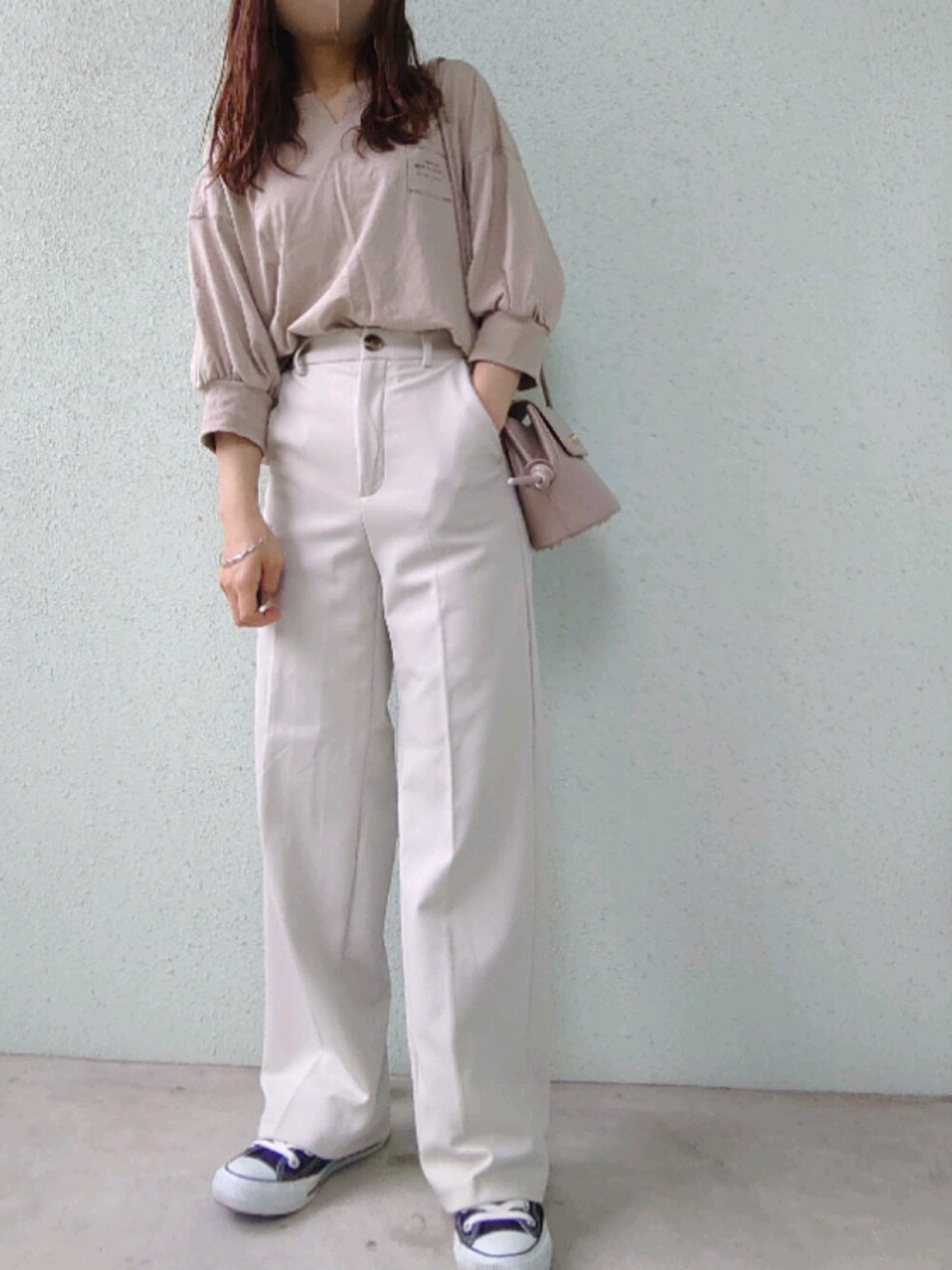 ベージュ系のトップス、ベージュ系のパンツ、ベージュ系のバッグを着用したレディースの春コーディネートの1枚目の写真