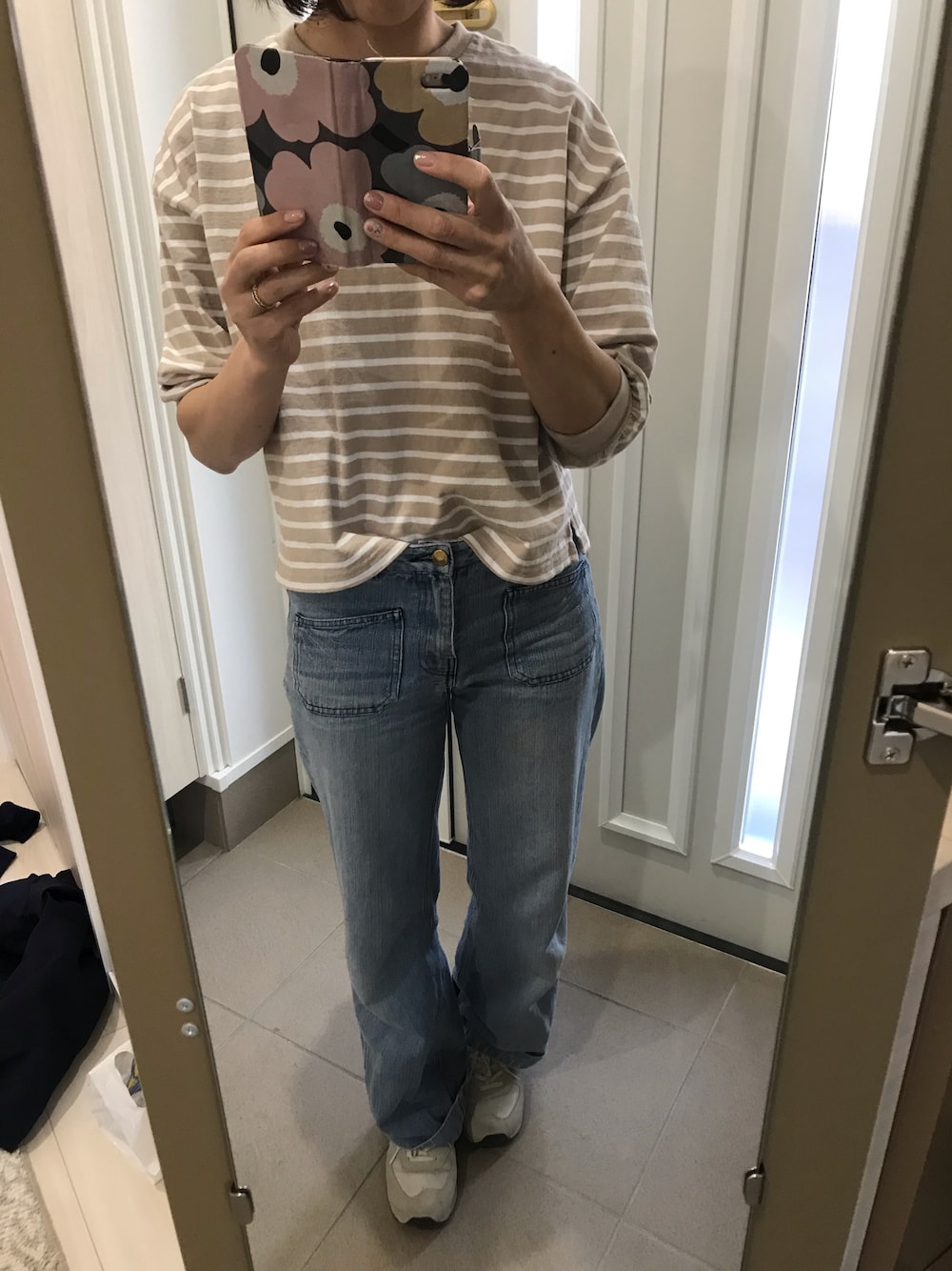 ベージュ系のTシャツ/カットソー、ブルー系のデニムパンツ、ホワイト系のスニーカーを着用したレディースの春コーディネートの1枚目の写真