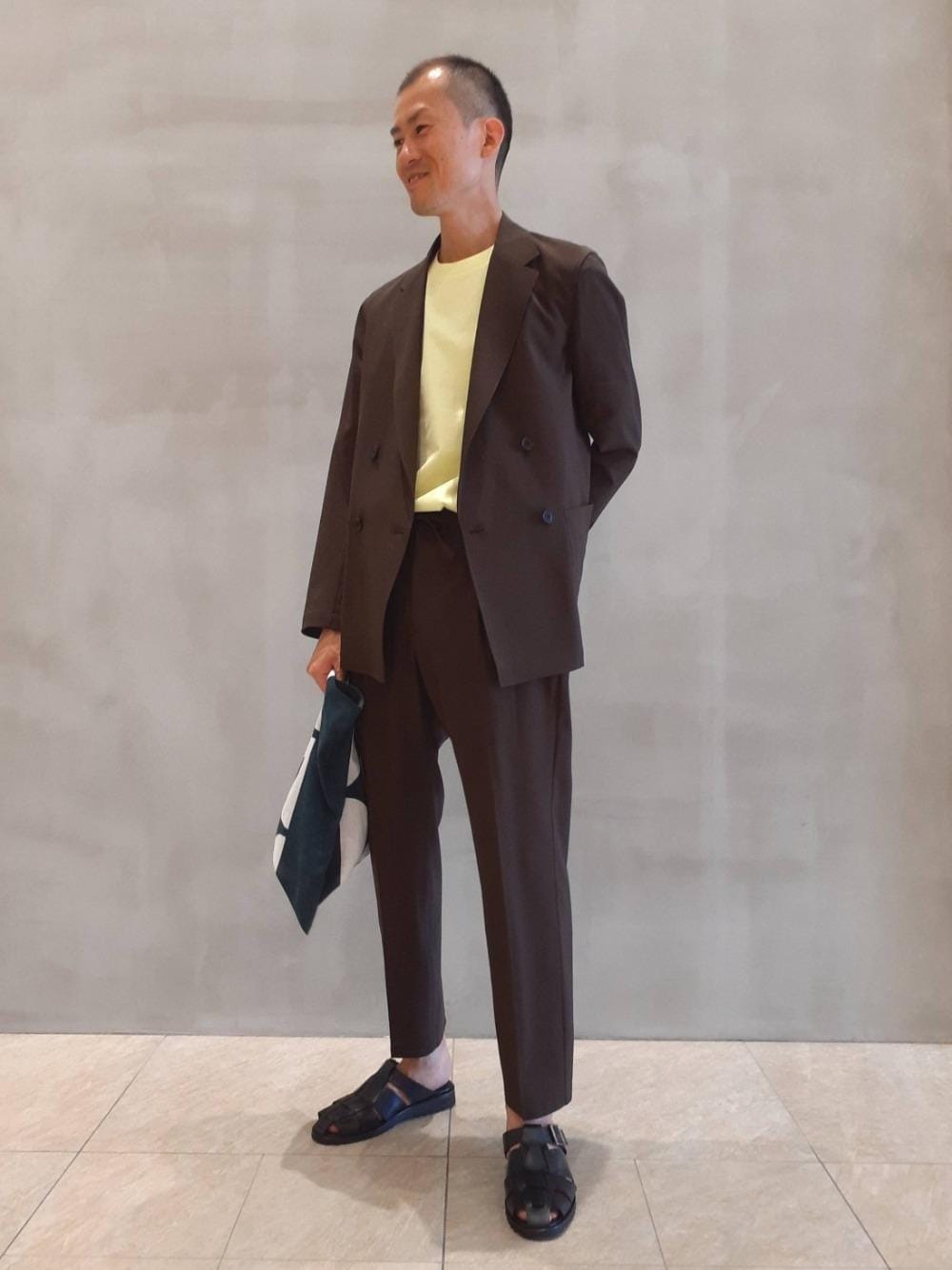ブラウン系のその他パンツ、ブラウン系のテーラードジャケット、イエロー系のTシャツ/カットソーを着用したメンズの夏コーディネートの1枚目の写真