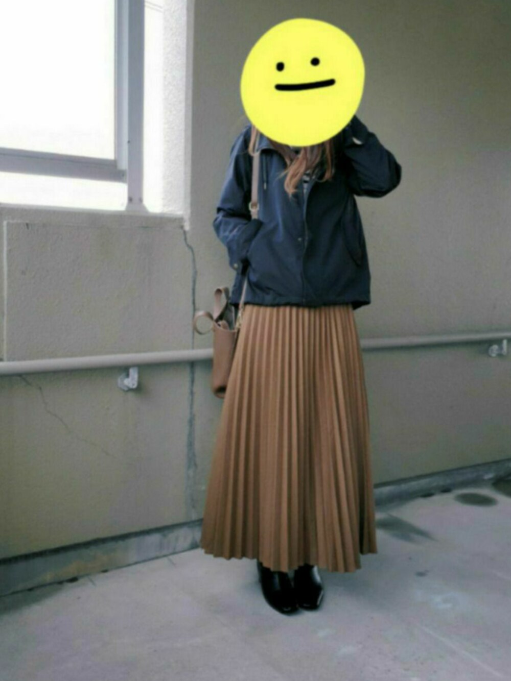 イエロー系のスカート、ブラック系のブーツ、ブラック系のTシャツ/カットソーを着用したレディースの冬コーディネートの1枚目の写真