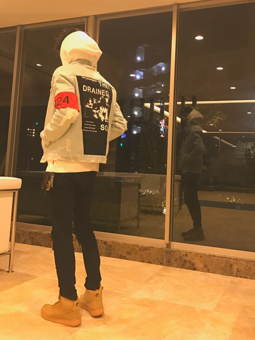 ホワイト系のデニムジャケット、ベージュ系のスニーカー、ホワイト系のその他トップスを着用したメンズの冬コーディネートの1枚目の写真