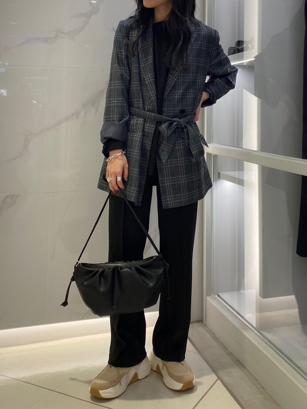 ブラック系のショルダーバッグ、ブラック系のその他パンツ、ベージュ系のスニーカーを着用したレディースの秋コーディネートの1枚目の写真