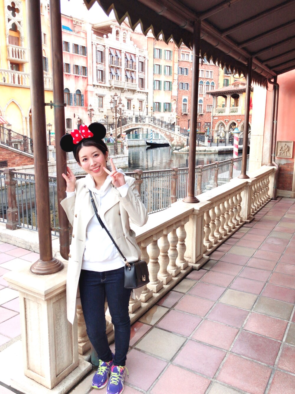 ベージュ系のトレンチコート、ホワイト系のパーカー、ブラック系のショルダーバッグを着用したレディースの春コーディネートの1枚目の写真