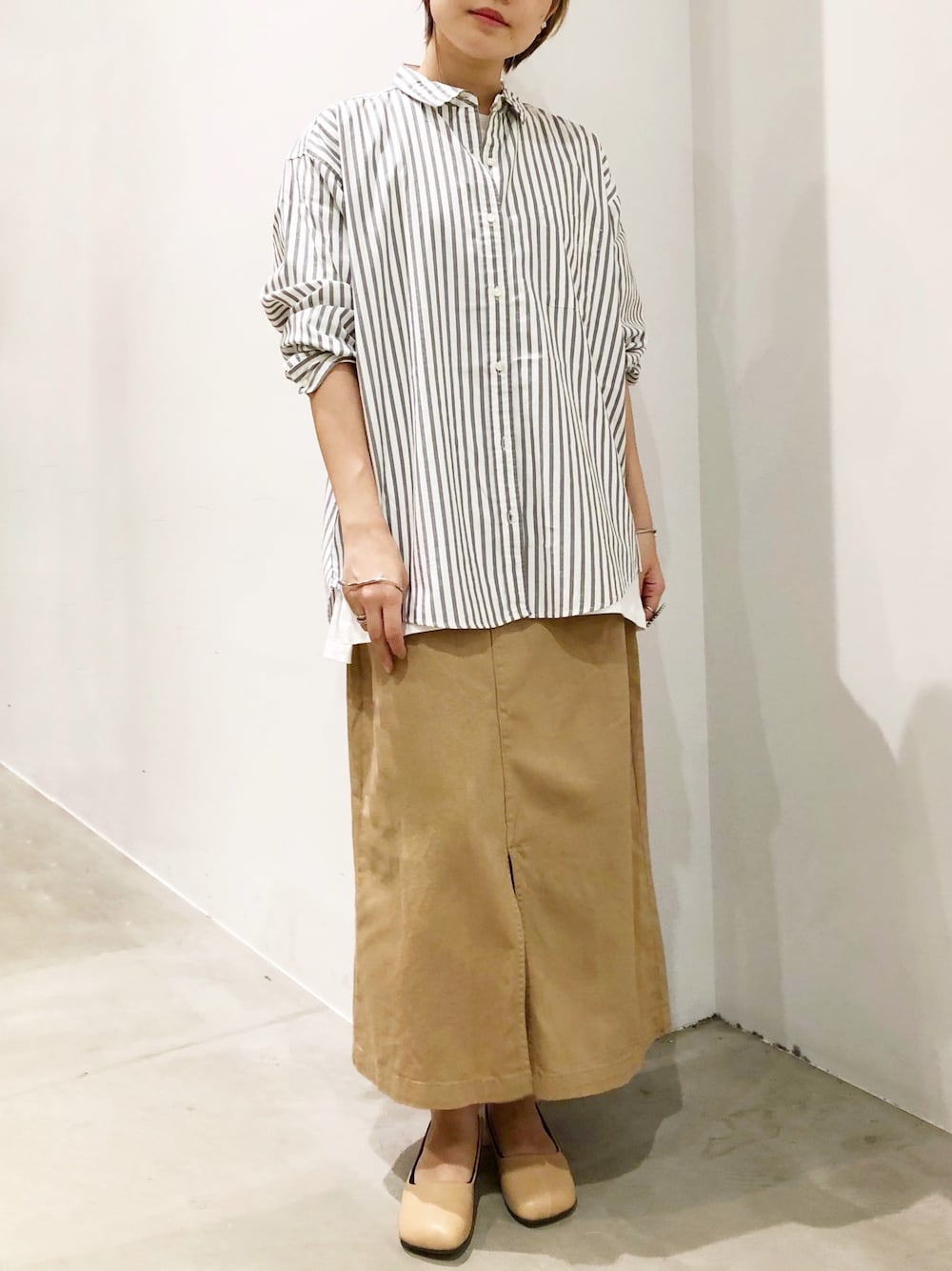 ベージュ系のパンプス、ベージュ系のスカート、その他のシャツ/ブラウスを着用したレディースの秋コーディネートの1枚目の写真