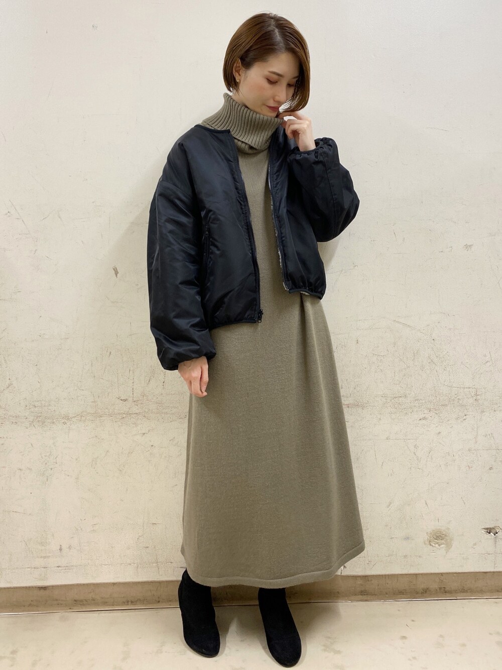 グレー系のブルゾン、ブラウン系のワンピース、ブラック系のブーツを着用したレディースの秋コーディネートの1枚目の写真