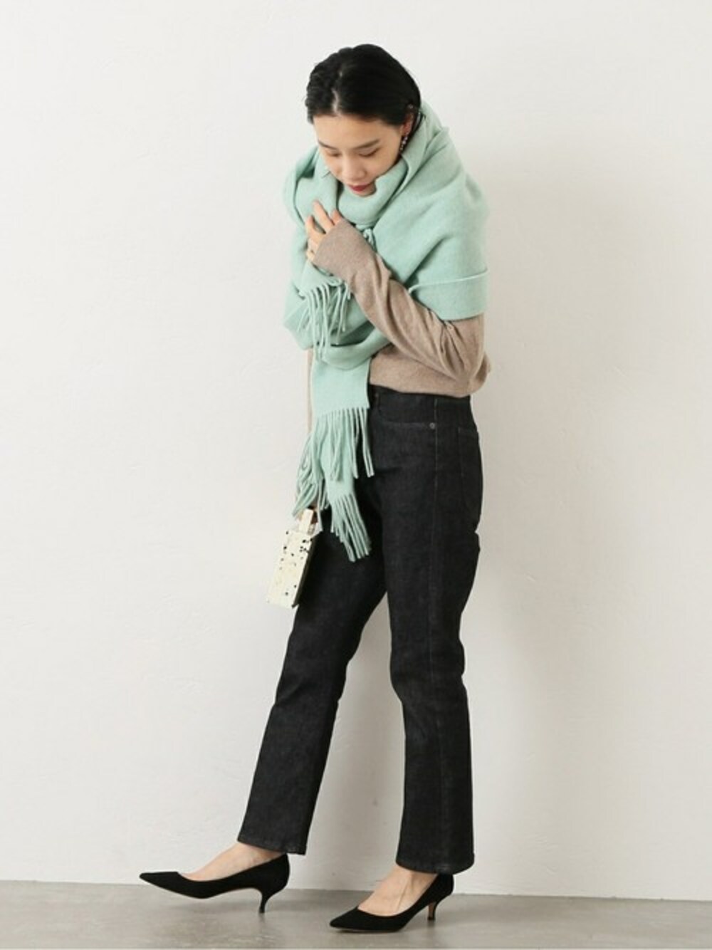 グリーン系のマフラーを着用したレディースの冬コーディネートの1枚目の写真