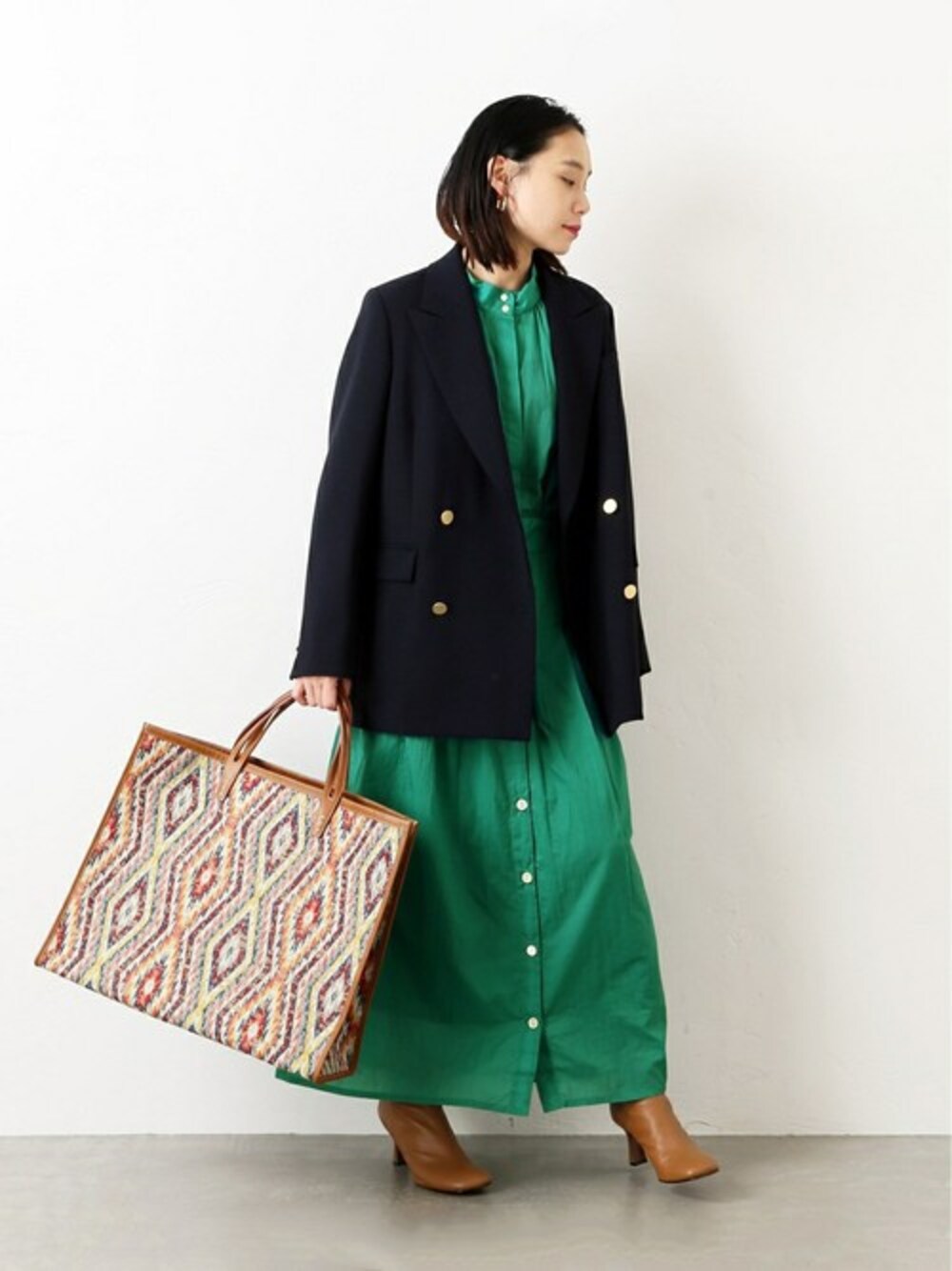 グリーン系のワンピースを着用したレディースの冬コーディネートの1枚目の写真