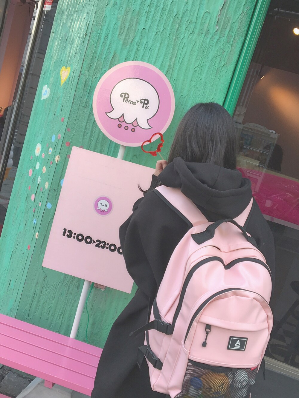 ブラック系のスウェット、ピンク系のバックパック/リュックを着用したレディースの冬コーディネートの1枚目の写真