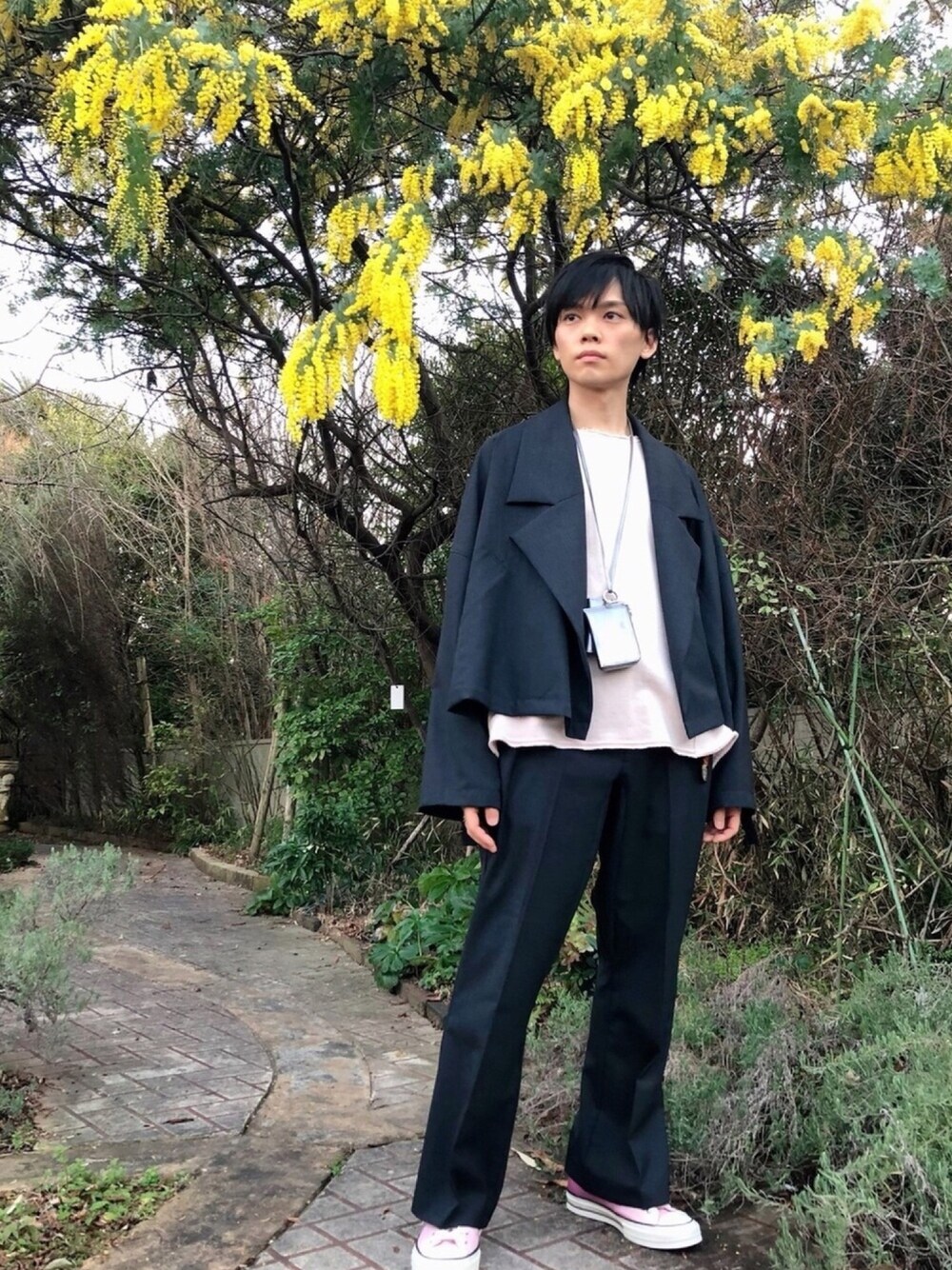 グレー系のブルゾン、ピンク系のスニーカー、ピンク系のスウェットを着用したメンズの冬コーディネートの1枚目の写真