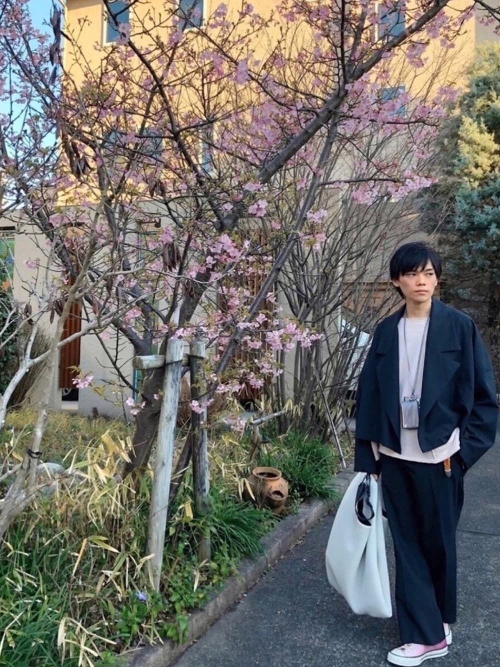 グレー系のブルゾン、グレー系のパンツ、ピンク系のスウェットを着用したメンズの冬コーディネートの1枚目の写真