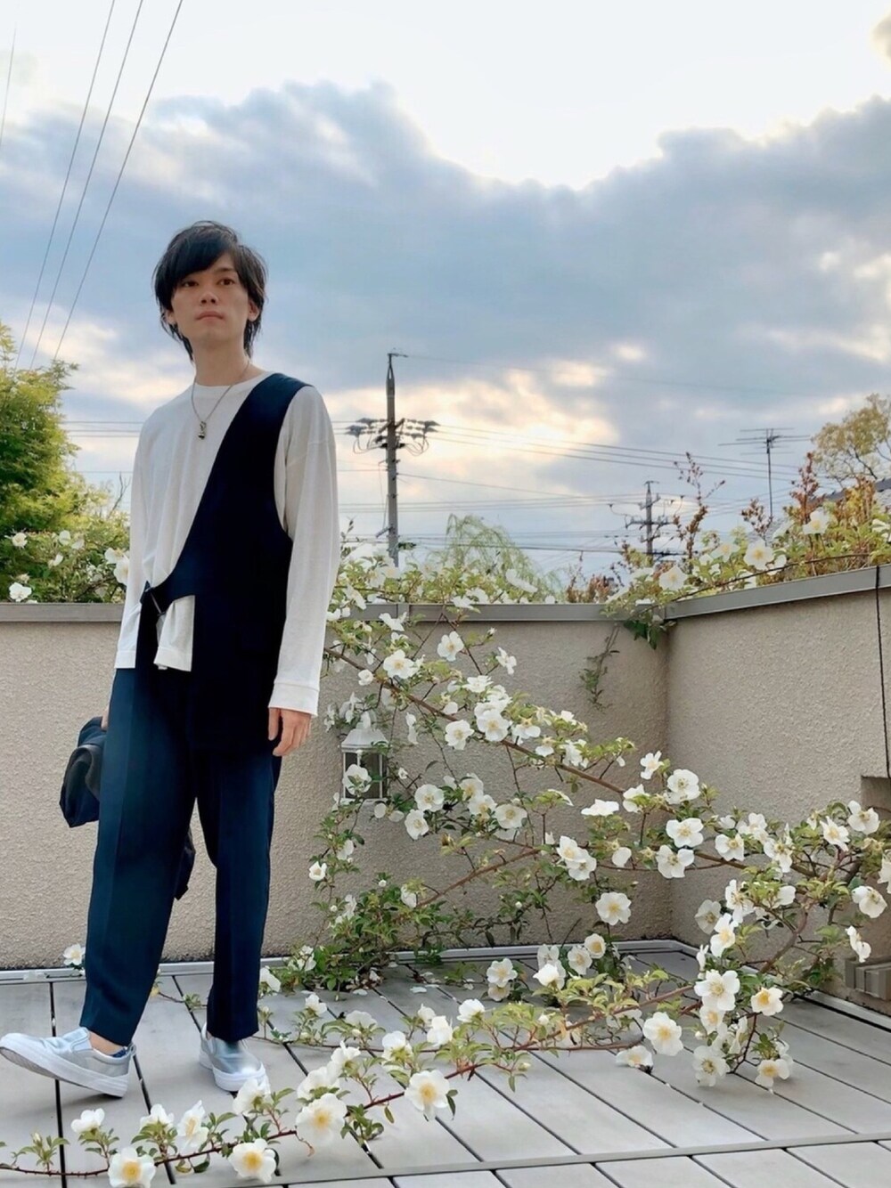 ホワイト系のTシャツ/カットソー、ブルー系のベスト、グレー系のスラックスを着用したメンズの春コーディネートの1枚目の写真