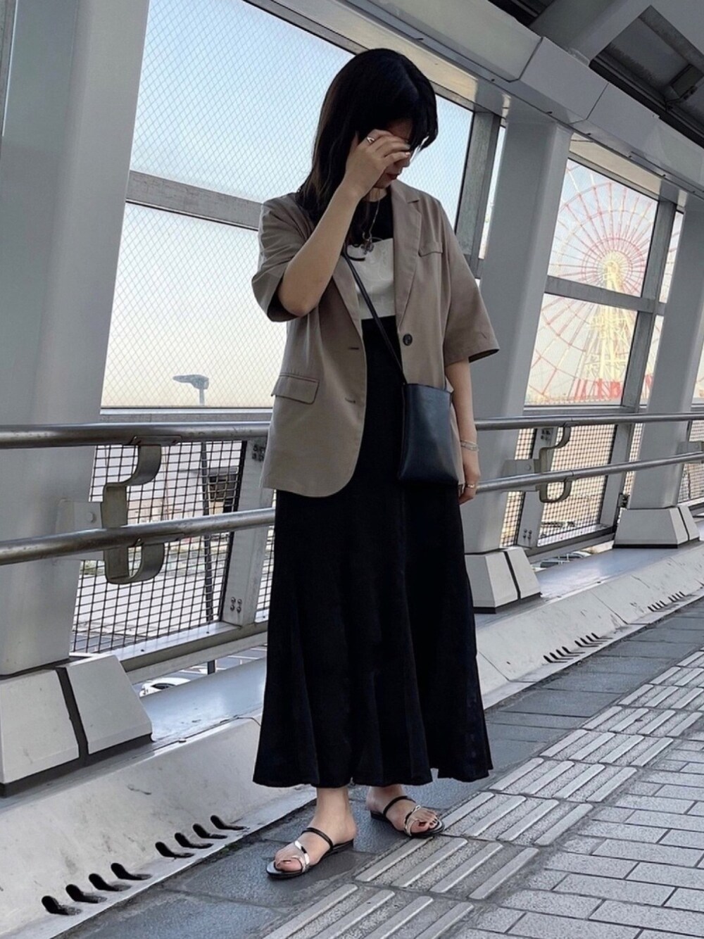 ブラック系のスカート、ベージュ系のテーラードジャケット、ブラック系のTシャツ/カットソーを着用したレディースの春コーディネートの1枚目の写真