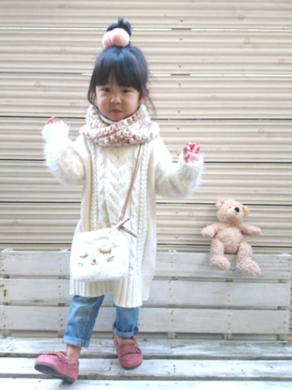 ホワイト系のワンピース、ブルー系のデニムパンツ、ホワイト系のショルダーバッグを着用したキッズの冬コーディネートの1枚目の写真