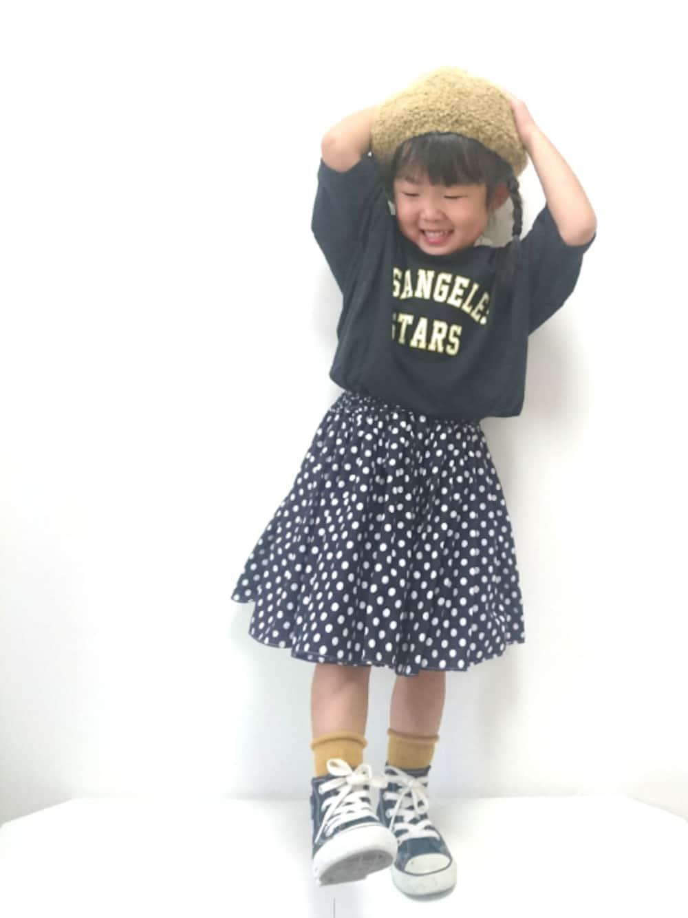 ブルー系のスカート、ブラック系のスニーカー、ブラック系のTシャツ/カットソーを着用したキッズの秋コーディネートの1枚目の写真