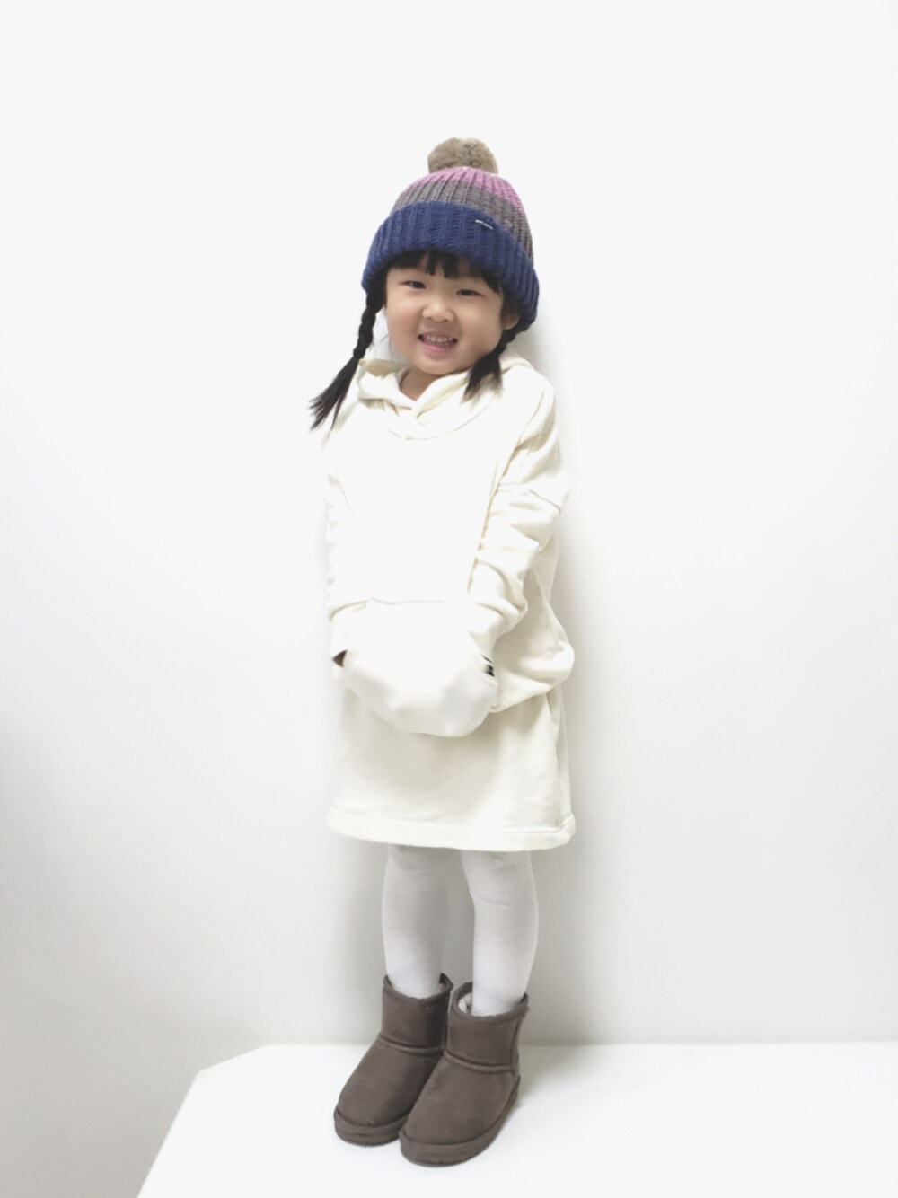 ホワイト系のワンピース、グレー系のブーツ、その他のニットキャップ/ビーニーを着用したキッズの冬コーディネートの1枚目の写真