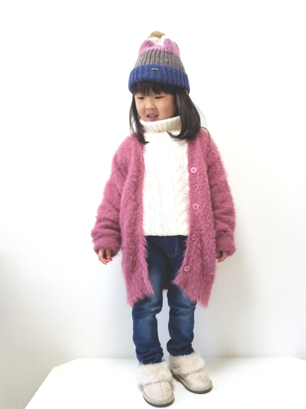 ブルー系のその他パンツ、ピンク系のカーディガン/ボレロ、ホワイト系のワンピースを着用したキッズの冬コーディネートの1枚目の写真
