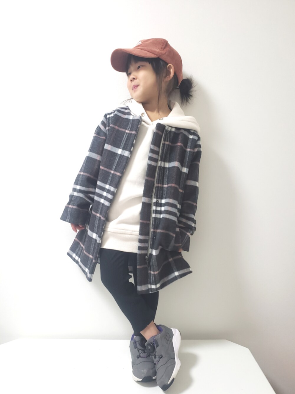 ホワイト系のパーカー、グレー系のスニーカー、グレー系のその他アウターを着用したキッズの冬コーディネートの1枚目の写真