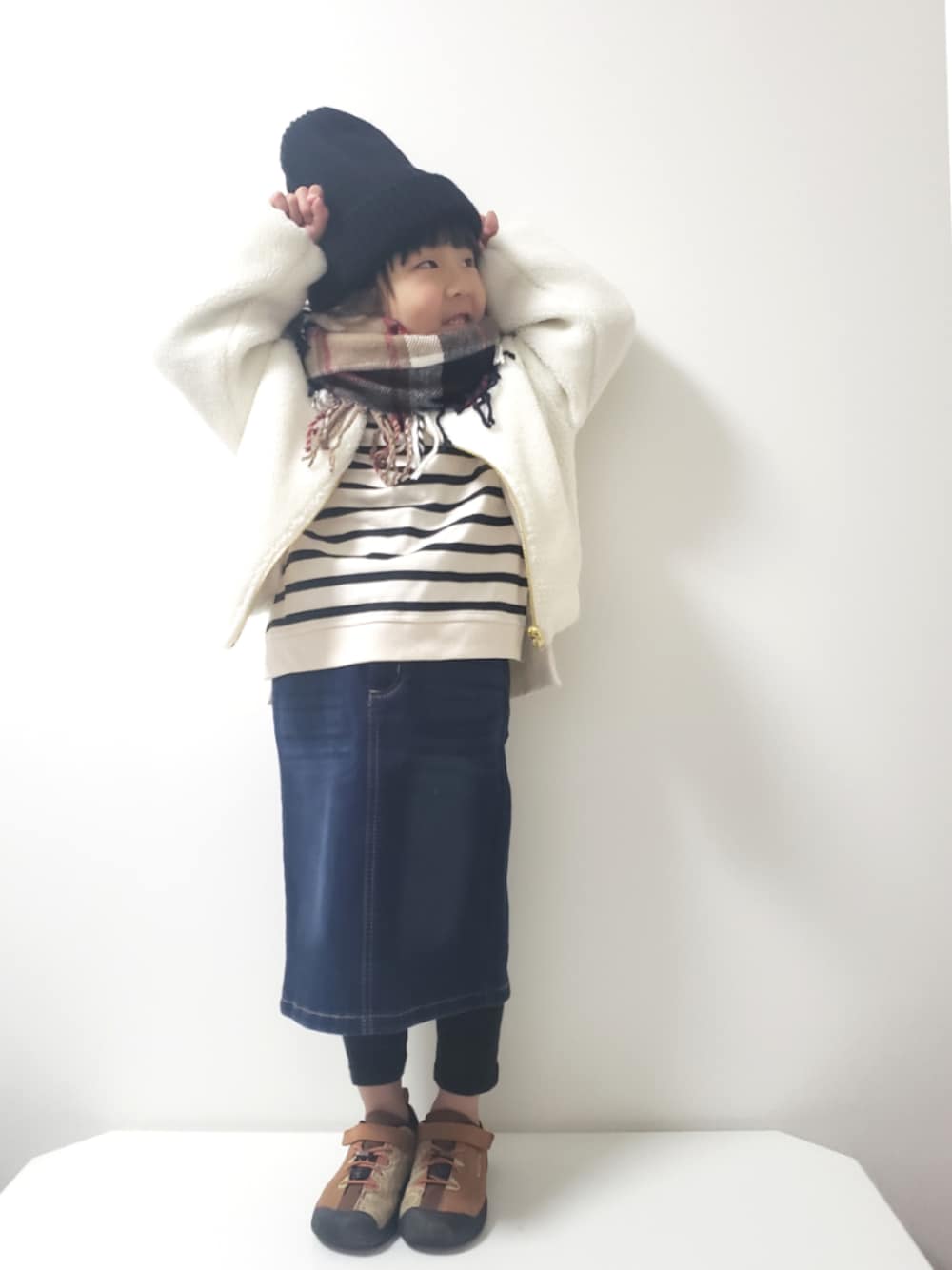 ブルー系のデニムスカート、ブラウン系のスニーカー、ホワイト系のTシャツ/カットソーを着用したキッズの冬コーディネートの1枚目の写真