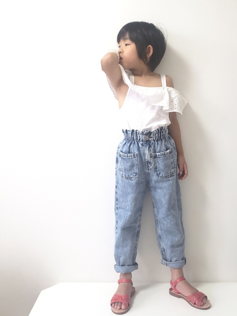 ブルー系のデニムパンツ、レッド系のサンダル、ホワイト系のTシャツ/カットソーを着用したキッズの夏コーディネートの1枚目の写真