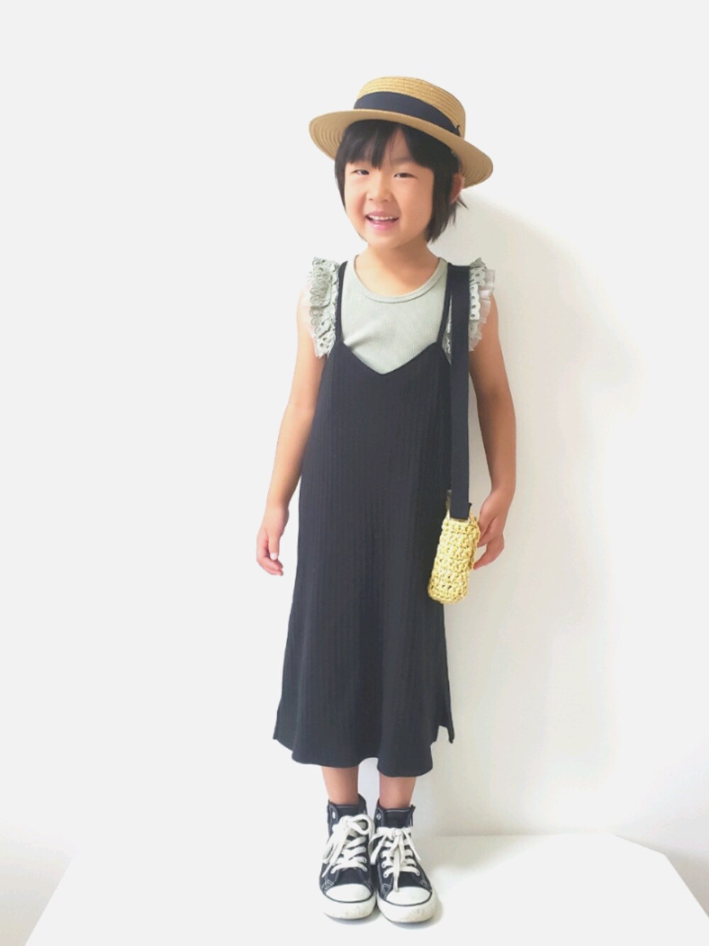 ブラック系のスニーカー、ベージュ系のショルダーバッグ、ブラック系のワンピースを着用したキッズの秋コーディネートの1枚目の写真