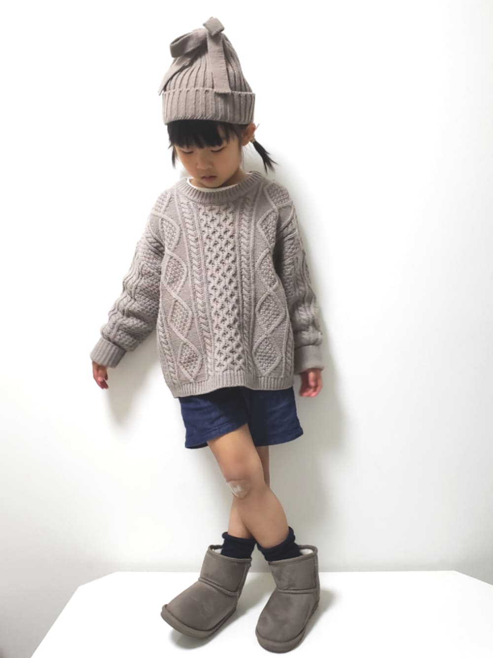 グレー系のブーツ、ブルー系のデニムパンツ、ブラウン系のニット/セーターを着用したキッズの冬コーディネートの1枚目の写真