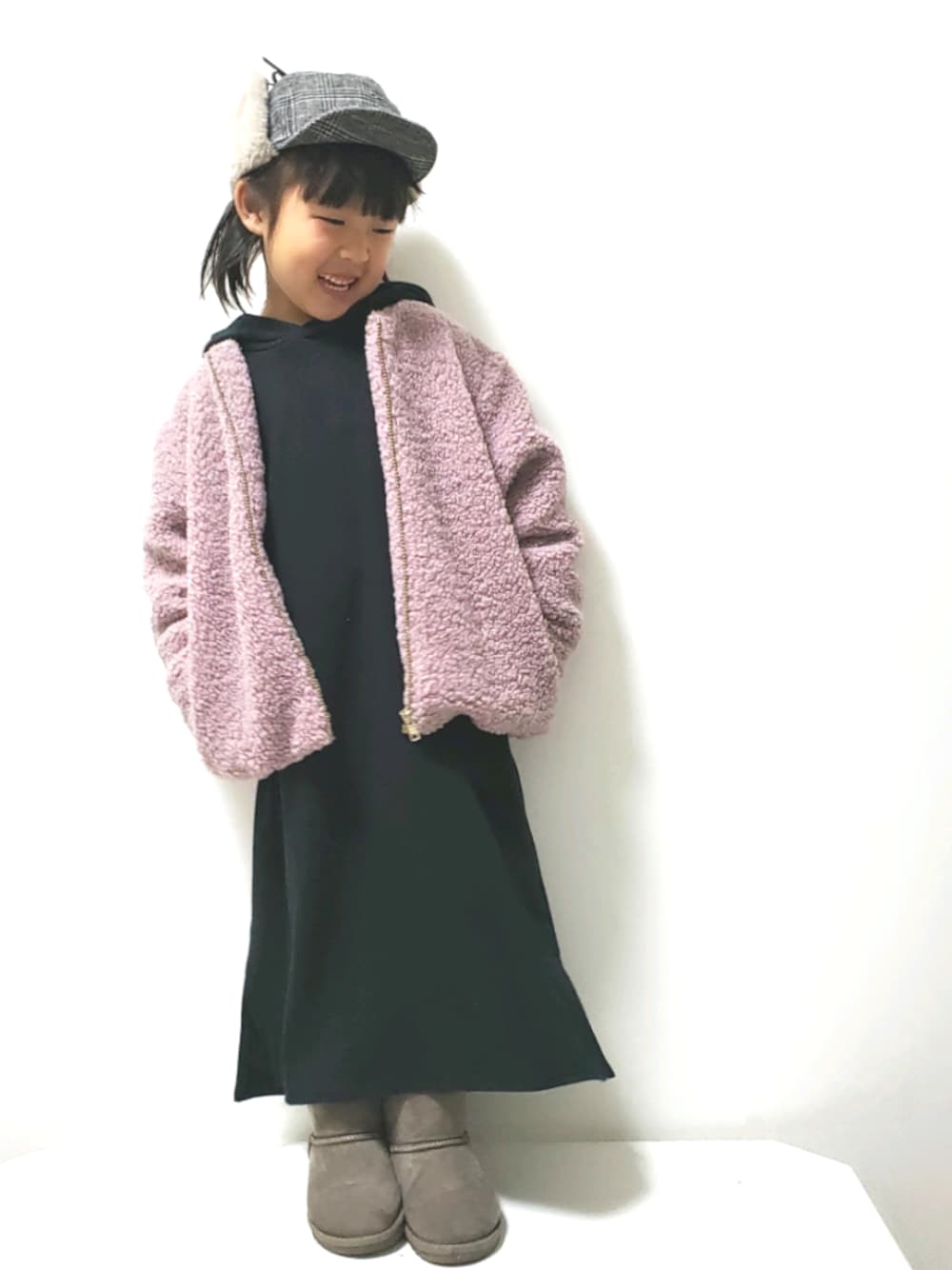 グレー系のブーツ、ブラック系のワンピース、ピンク系のジャケット/アウターを着用したキッズの冬コーディネートの1枚目の写真